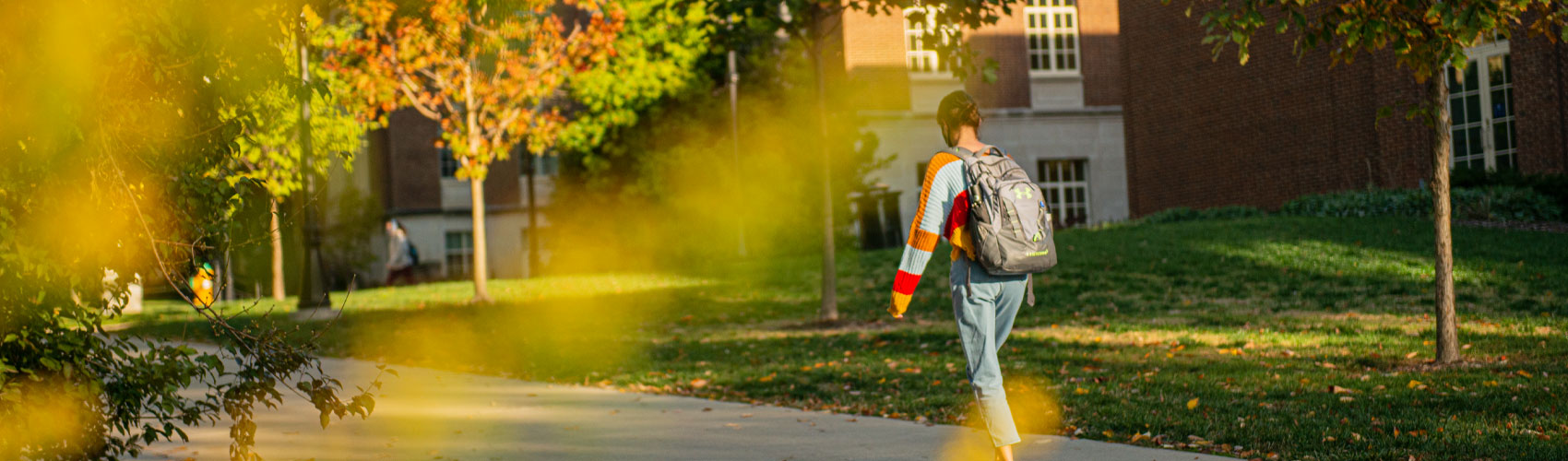 Student walking through campus with backpack